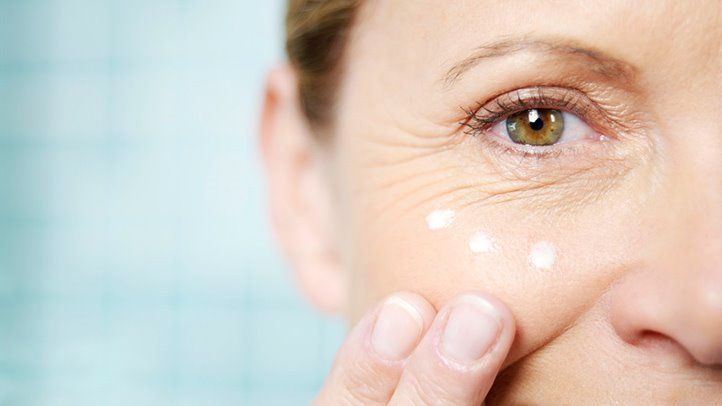 Woman applying lotion on her face